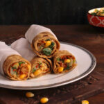 Corn Spinach Kathi Roll stacked on a white plate