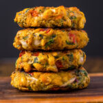Vegan Corn Fritters stacked on a wooden table