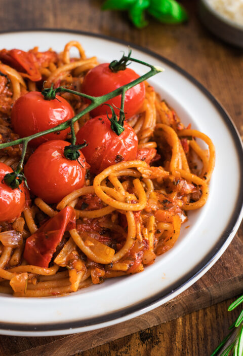 Roasted Cherry Tomatoes Pasta on a white plate over a wooden table