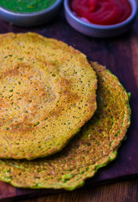 Matar Cheela Recipe on a wooden platter with green chutney and ketchup